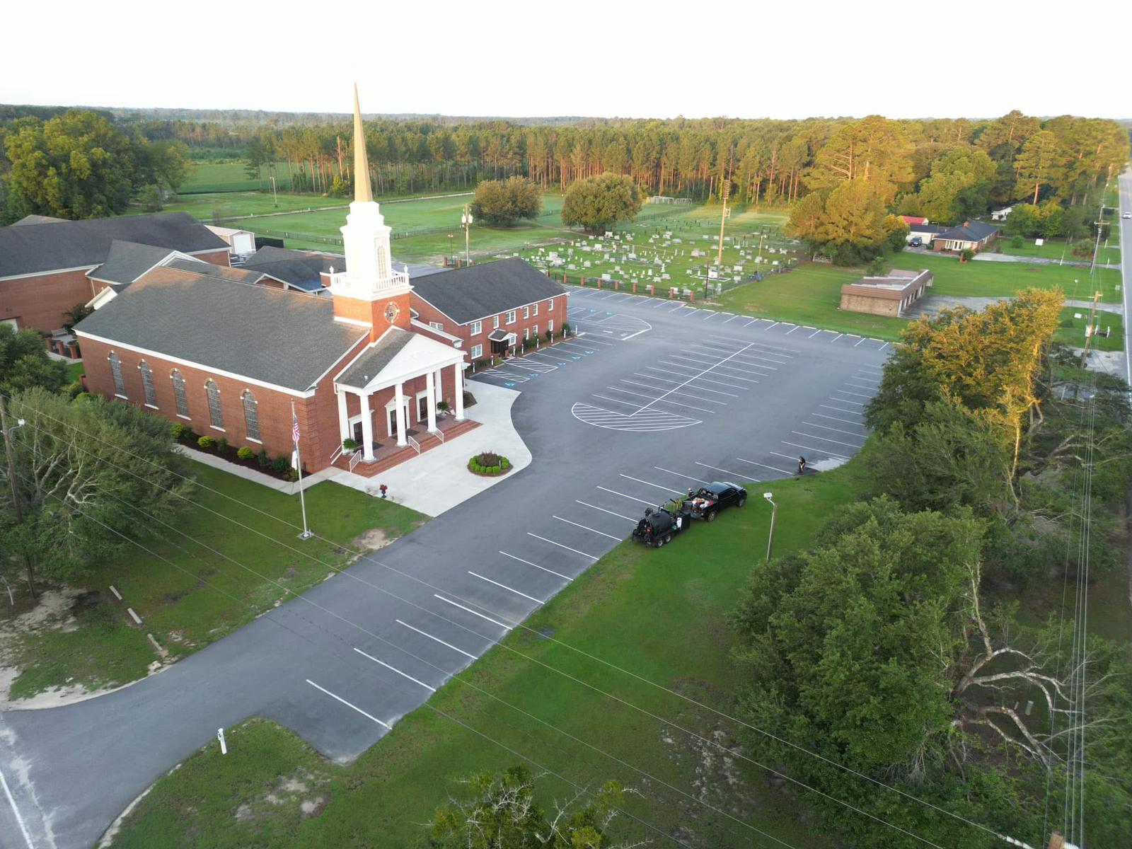 Drone shot of completed seal coating and striping project at church facility showing professional results
